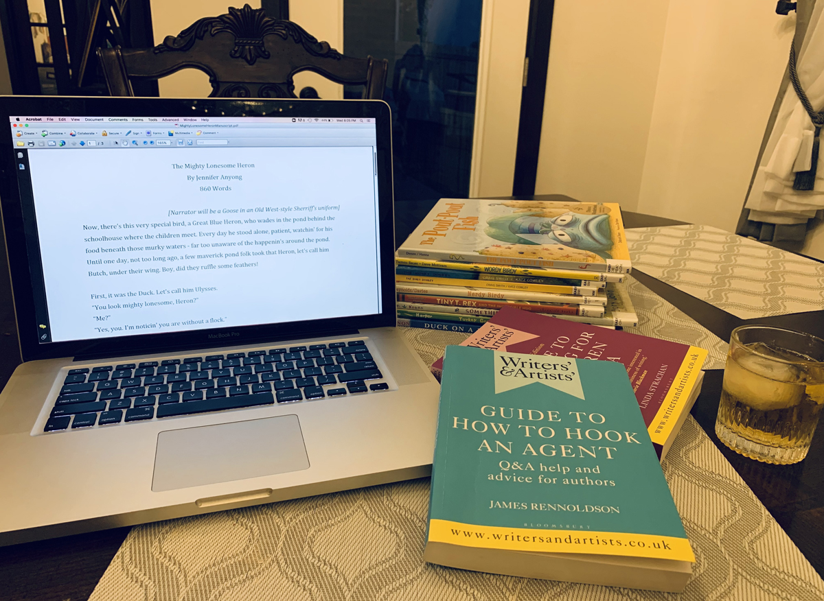 Jen's laptop computer with a stack of picture books from the library with two new books, "Guide to How to Hook an Agent" and another new book about writing for children